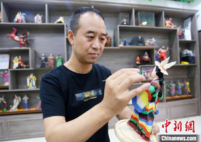 圖為安秋平正在創(chuàng)作代表隴南文縣民俗的《白馬人》作品?！「哒?攝