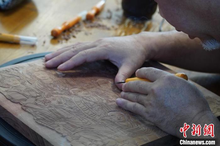 圖為徐晉林湊近木板，近距離制作雕版畫。　九美旦增 　攝