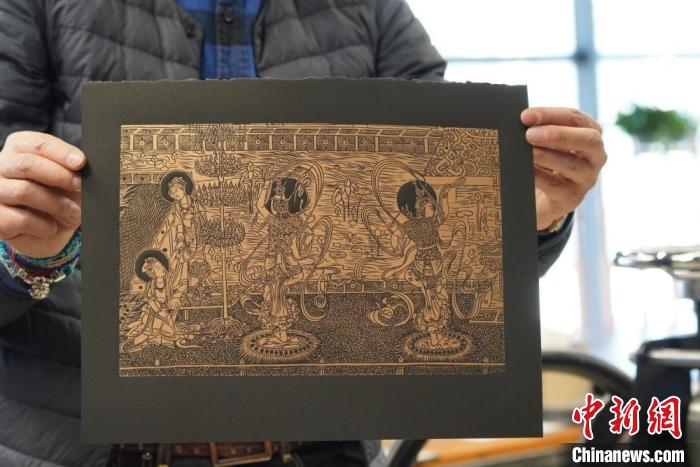 圖為手工書藝人展示敦煌雕版壁畫印刷品?！【琶赖┰?　攝