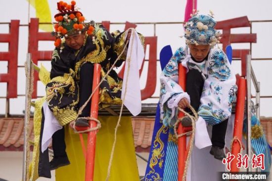 圖為“苦水高高蹺”表演者通過麻繩將腳固定在腳踏板，并在腿部纏繞六七圈?！【琶赖┰?攝