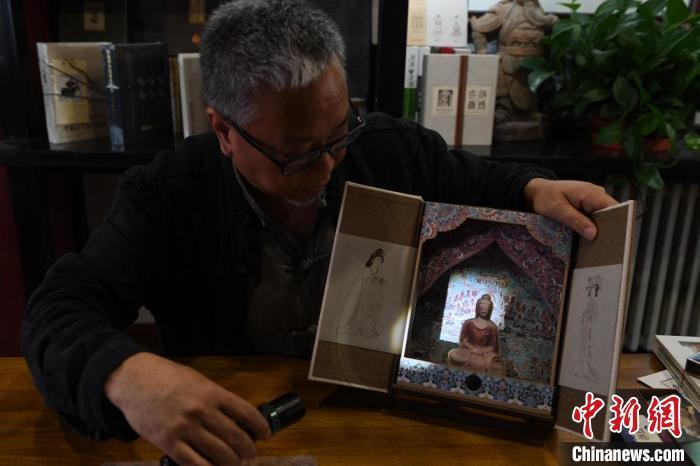 圖為讀者出版集團讀者晉林工作室獨立出品人徐晉林，展示互動性強的敦煌題材手工書。(資料圖) 楊艷敏 攝