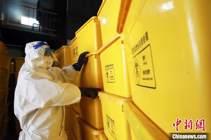 圖為工作人員搬運(yùn)醫(yī)療廢物專用周轉(zhuǎn)箱?！∥航ㄜ?攝