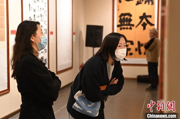 圖為甘肅蘭州，參展書(shū)法作品吸引參觀者。 中新社記者 李亞龍 攝