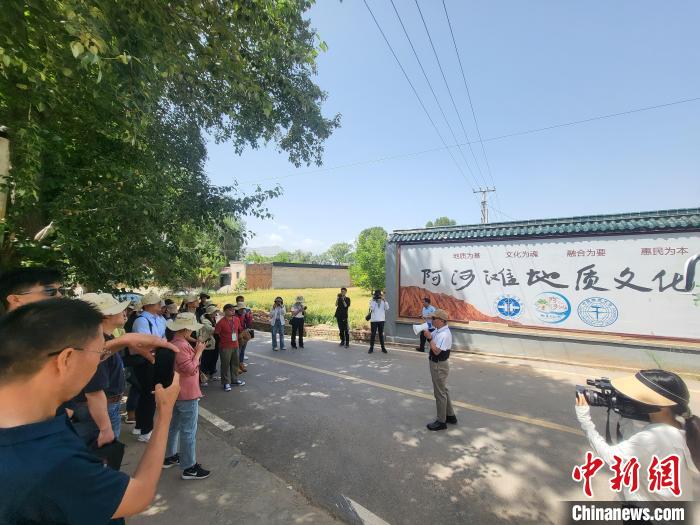 圖為中國地質(zhì)大學(xué)(北京)教授張緒教介紹村落情況?！『衍?攝