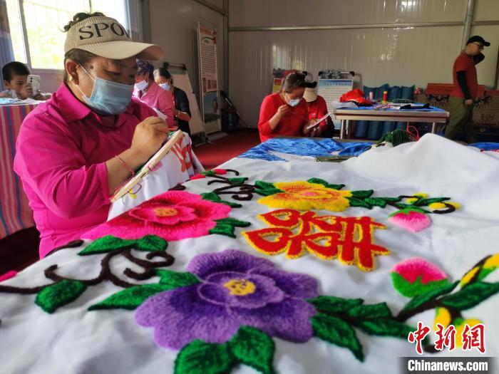 圖為婦女制作青繡?！?zhí)砀?攝