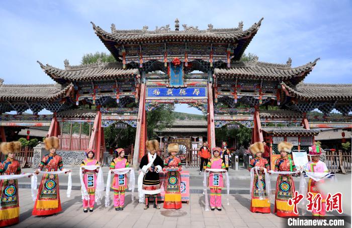 圖為身穿土族服飾的工作人員迎接訪客?！⊙Φ?攝