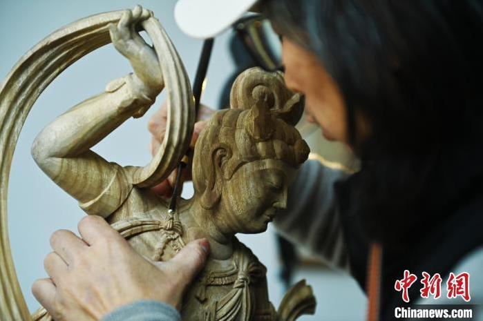 圖為季茂杰進(jìn)行敦煌元素的木雕創(chuàng)作。李亞龍 攝</p>
<p>