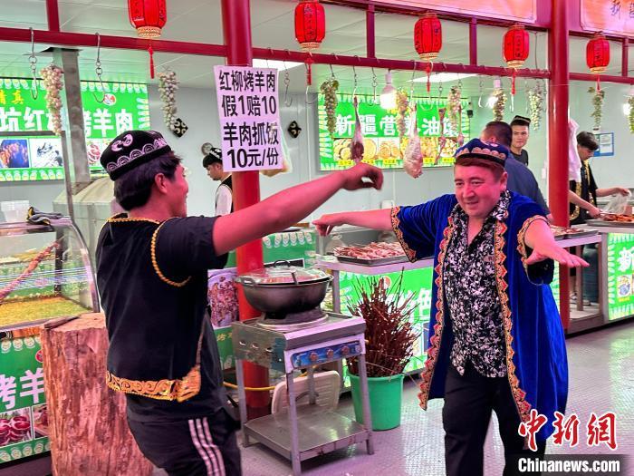 圖為餐飲經(jīng)營者在“西涼不夜城”跳起舞蹈引客?！〈魑牟?攝</p><p>