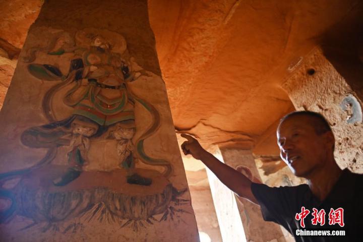 7月15日，甘肅省平?jīng)鍪袥艽h百里石窟長(zhǎng)廊羅漢洞石窟內(nèi)，該窟文保員郭建平介紹窟內(nèi)石刻彩繪壁畫。郭建平家中三代人曾自發(fā)保護(hù)羅漢洞石窟。羅漢洞石窟遺存40余個(gè)窟龕，以北魏至清代風(fēng)格為主。中新社記者 李亞龍 攝</p>
<p>