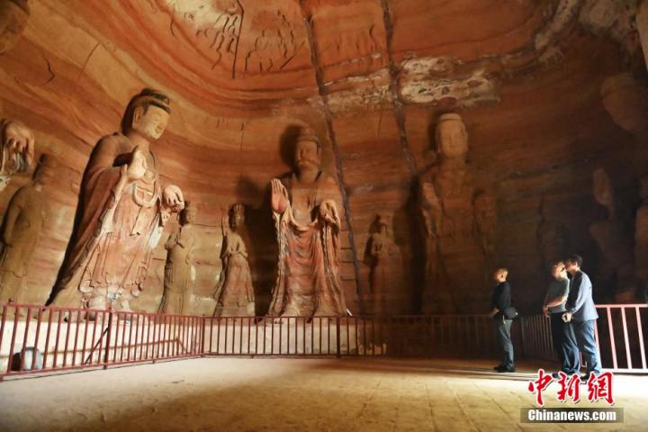 7月15日，游人參觀甘肅省平?jīng)鍪袥艽h百里石窟長(zhǎng)廊中的南石窟寺1號(hào)窟。百里石窟長(zhǎng)廊位于涇川縣境內(nèi)，由512個(gè)石窟、5眼窟中石井組成，現(xiàn)存王母宮石窟、鳳凰山石窟、南石窟寺、丈八寺石窟、羅漢洞石窟、太山寺石窟等規(guī)模較大的石窟群，還有數(shù)量眾多的小石窟群。南石窟寺開鑿于北魏永平三年，其中1號(hào)窟屬于大型七佛窟，七佛高達(dá)6米。中新社記者 李亞龍 攝