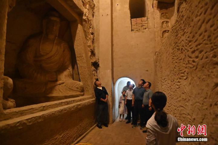 7月15日，游人參觀甘肅省平?jīng)鍪袥艽h百里石窟長(zhǎng)廊中的王母宮石窟。百里石窟長(zhǎng)廊位于涇川縣境內(nèi)，由512個(gè)石窟、5眼窟中石井組成，現(xiàn)存王母宮石窟、鳳凰山石窟、南石窟寺、丈八寺石窟、羅漢洞石窟、太山寺石窟等規(guī)模較大的石窟群，還有數(shù)量眾多的小石窟群。王母宮石窟又名千佛洞，該窟設(shè)計(jì)宏大，造像生動(dòng)，窟內(nèi)擁有造像數(shù)百尊，是較為珍貴的佛教文化歷史遺存。中新社記者 李亞龍 攝</p>
<p>