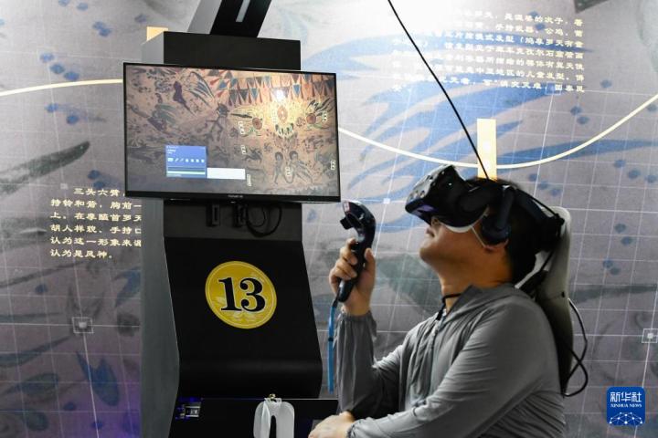 7月22日，游客借助VR設(shè)備沉浸式游覽莫高窟第285窟虛擬場(chǎng)景。新華社記者 郎兵兵 攝